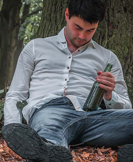 мужчина с бутылкой спит под деревом
